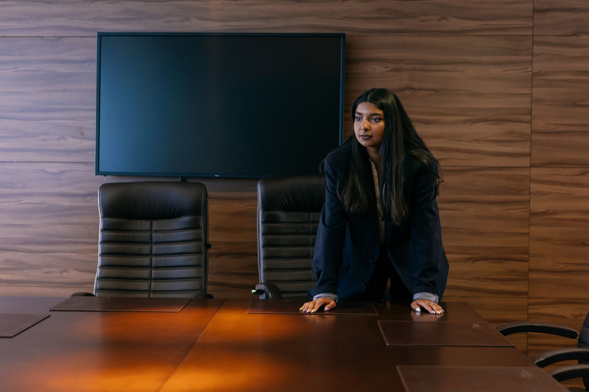 Person standing beside a meeting table